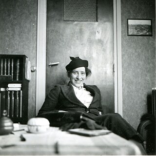 Filmstill fra "Hannah Arendt - Facing Tyranni": Hannah Arendt sidder i en lænestol med et stort smil på læben.