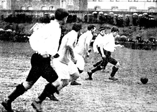 Image from the 1930 showing the rush of a group of young men on the soccer field.