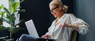 Woman sitting on chair with laptop