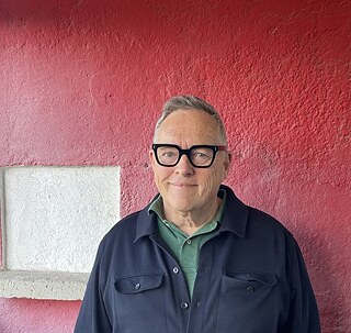Thomas Meinecke in front of red wall