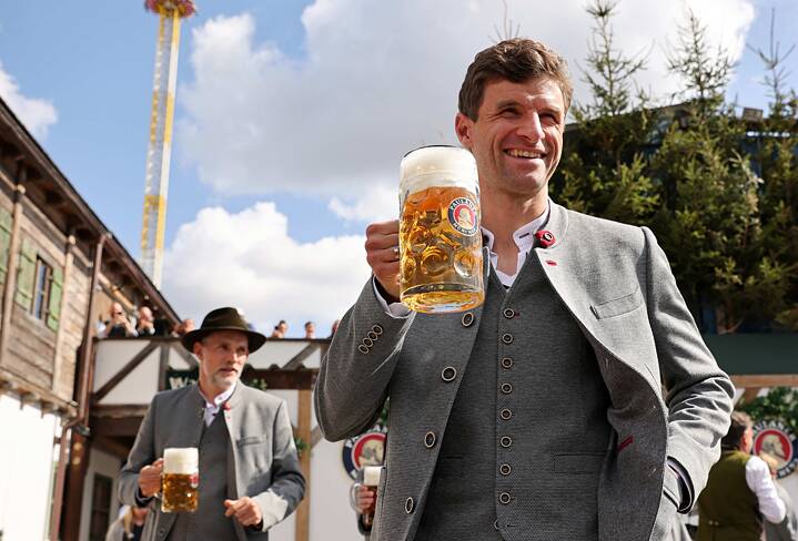 Thomas Müller trinkt eine Mass Paulaner-Bier beim Oktoberfestbesuch.