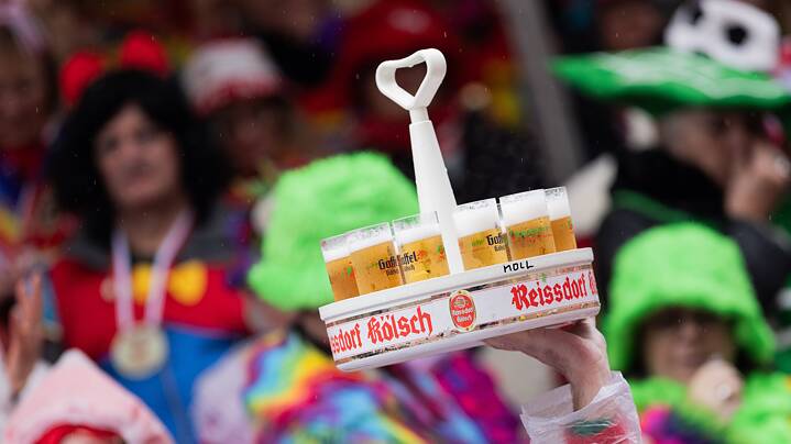 Ein Kranz Kölsch wird an Weiberfastnacht durch die Menge getragen.