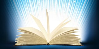 Ein aufgeschlagenes Buch, aus dem Lichtstrahlen scheinen.