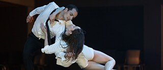 Tanečník a tanečnice v objetí. 