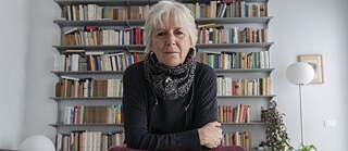 Portrait of a woman in front of a bookshelf 