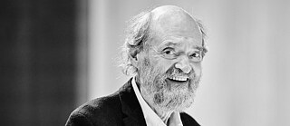 A black-and-white portrait of a smiling man