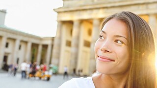 A young woman looks cheerfully into the camera.