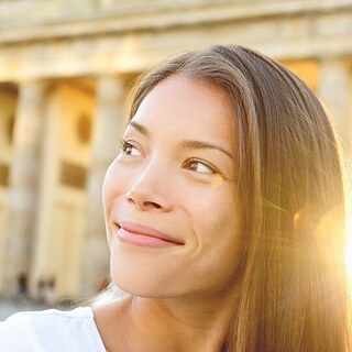 A young woman looks cheerfully into the camera.