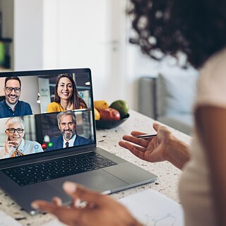 Frau vor Laptop sitzend in einer Videokonferenz
