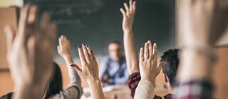 Maos de alunos numa sala de aula
