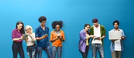 Vor einem blauen Hintergrund schauen 4 junge Menschen gemeinsam auf ihre Handys und Tablets 