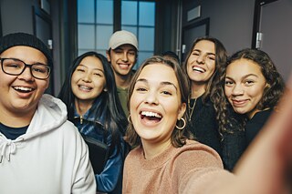 eine Gruppe junger Menschen nimmt ein Selfie auf.