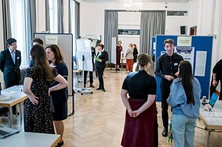 Finalisten stehen an ihren Ständen und präsentieren ihre Forschungsprojekte.