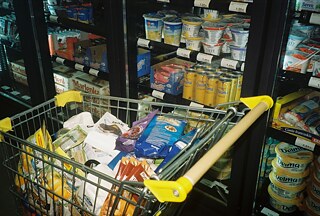 Nákupný košík pri chladiacich boxoch plných mliečnych výrobkov, masla a dezertov. Pre nárast ukrajinskej klientely Łowiczanka postupne rozširuje sortiment o ukrajinské produkty.