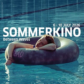 Διαφημιστικό banner για «Sommerkino – Ανάμεσα στα κύματα» (6–10 Ιουλίου 2026): Ένα άτομο ξαπλώνει χαλαρά πάνω σε σκοτεινό φουσκωτό σωσίβιο που επιπλέει σε μπλε νερό, πιθανώς πισίνα ή λίμνη. Μεγάλο λευκό κείμενο εμφανίζει τον τίτλο και τις ημερομηνίες.