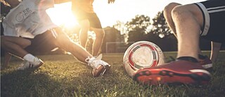 Aufnahme des Fußes einer Person, die einen Ball in ein Tor schießt. 