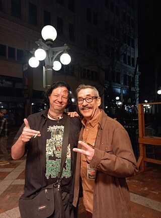  Foto de Jan Röhlk con Greg Norton, Minneapolis–Saint Paul, 2025 - “Siguiendo los pasos de Hüsker Dü, le hablé en un concierto. Al día siguiente me gritó desde la entrada de otra sala: '¡Hey, Jan!', su mujer sacó la foto”.