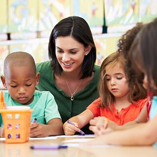 Vorschüler mit Lehrerin im Kunstunterricht.