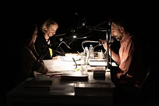Theaterschaffende um einen Tisch 