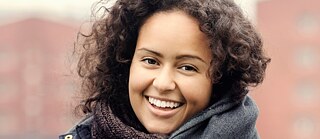 En ung tysklærer ser venligt og smilende ind i kameraet.​
