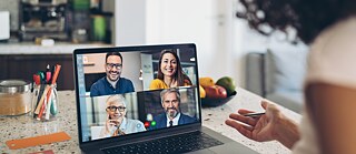 Frau vor Laptop sitzend in einer Videokonferenz