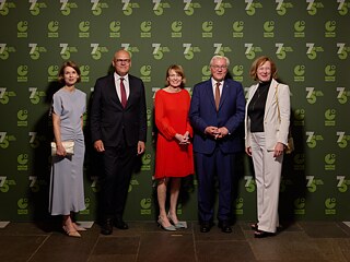 Doreen Kirmse, Johannes Ebert, Elke Büdenbender, Frank-Walter Steinmeier und Gesche Joost posieren für ein Gruppenfoto vor der Jubiläumswand mit dem Logo des Goethe-Instituts. 