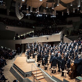 Orchester sa klania po koncerte v koncertnej sále.