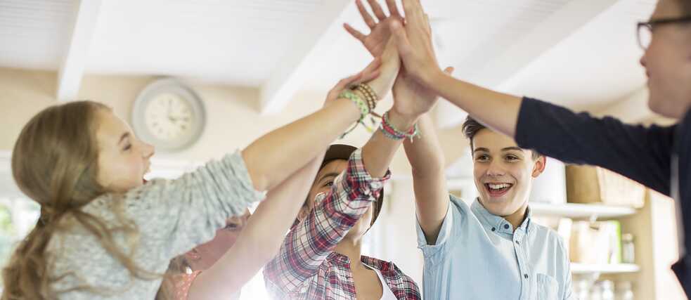  Schüler*innen geben sich ein High Five