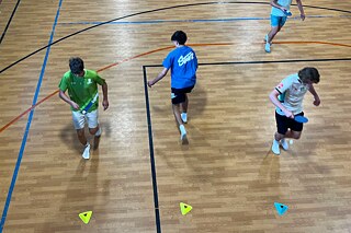 Jugendliche laufen einen Parkour und halten dabei einen Ping-Pong Ball in der Luft.