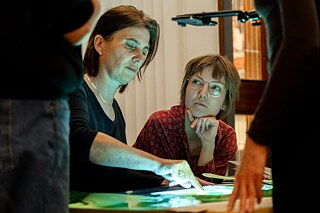 two women using a table for stop motion animation