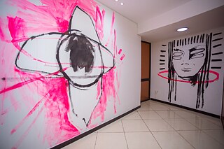 Zwei großformatige Wandgemälde mit abstrakten Figuren- und Porträtmotiven in der Ausstellung „Elima-NoBody“ im Musée d'Art Contemporain et Multimédia in Kinshasa.