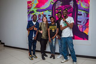 Fünf Personen posieren vor einem großformatigen, expressiven Gemälde bei der Vernissage der Ausstellung „Elima-NoBody“ im Musée d'Art Contemporain et Multimédia in Kinshasa.