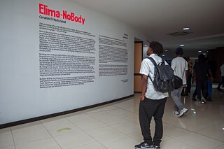 Besucher liest die Einführungstexte zur Ausstellung „Elima-NoBody“ auf einer Museumswand im Musée d'Art Contemporain et Multimédia in Kinshasa.