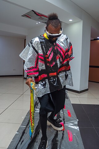 Performance mit futuristischem Kostüm aus silberfarbenem Material bei der Ausstellung „Elima-NoBody“ im Musée d'Art Contemporain et Multimédia in Kinshasa.