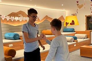 Zwei Jugendliche spielen „Schere, Stein, Papier“.