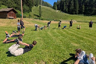 Jugendliche beim Sport auf einer Wiese.