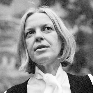 Auf einem Schwarz-Weiß-Foto ist die österreichische Schriftstellerin Ingeborg Bachmann zu sein, einen Mittelscheitel tragend, ihre linke Hand ist durch eine gestikulierende Bewegung nur verschwommen zu sehen.