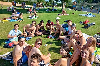Jugendliche auf einer Wiese in einem Freibad.