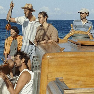 Vier Männser und eine Frau auf einem Segelschiff