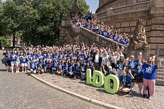 Die Teilnehmenden der Internationalen Deutscholympiade 2026 vor dem Wasserturm in Mannheim.