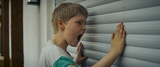 Scene from the movie "Punching the World", young boy punches a wall