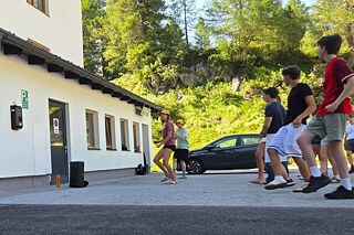 Jugendliche tanzen auf einem gepflasterten Hof.