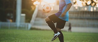 Junge mit Fußball auf einem Feld