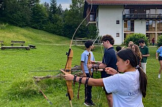 Jugendliche beim Bogenschießen.