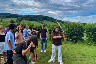 Jugendliche beim Bogenschießen.