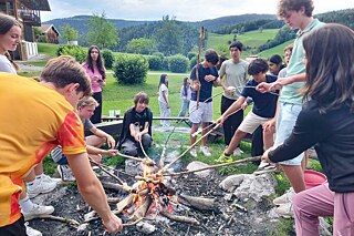 Jugendliche grillen Marshmallow über einem offenen Feuer.