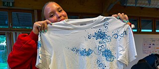 Jugendliche präsentiert ihr selbst gestaltetes T-Shirt