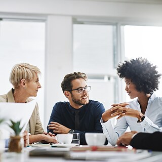 A group of people discussing in the office