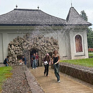 Jugendliche erfreuen sich an den Wasserspielen Hellbrunn.