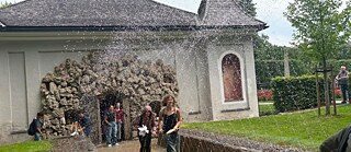 Jugendliche erfreuen sich an den Wasserspielen Hellbrunn.